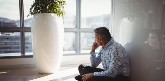 Thoughtful executive sitting on floor